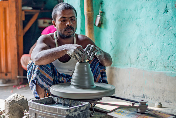 Man making a chai cup on pottery wheel